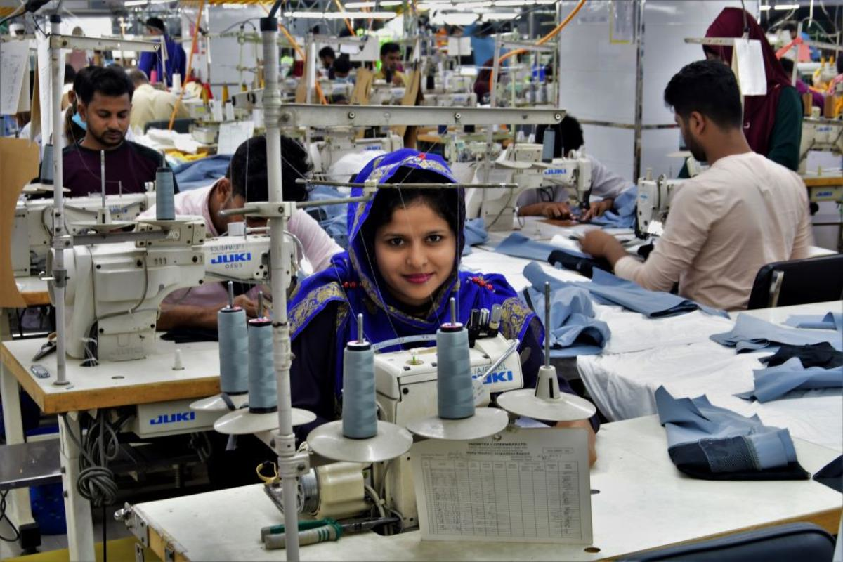 Indian textile workers operating sewing machines in busy garment production factory